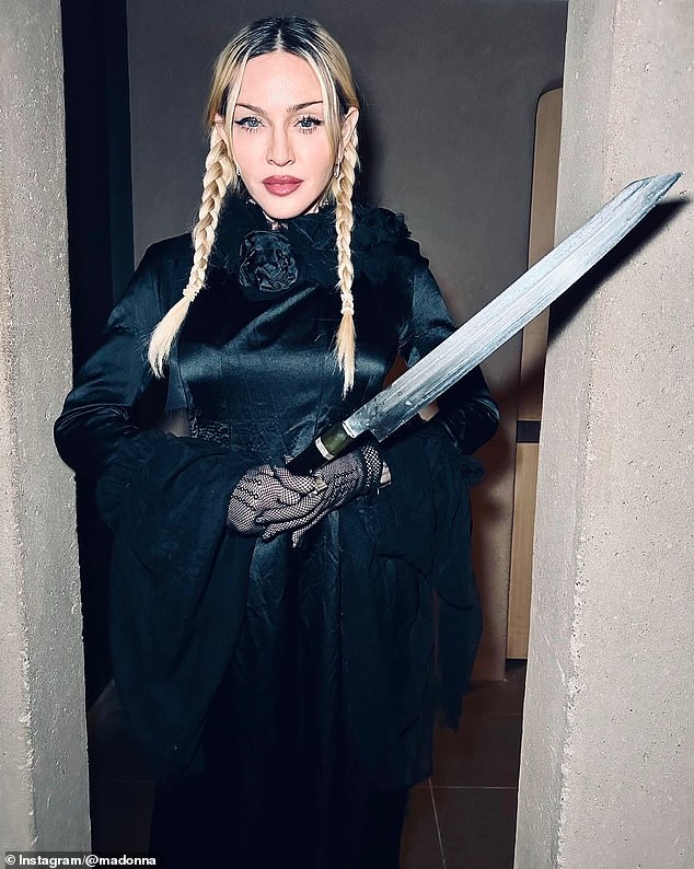 In one snapshot, she posed with a sword as she modeled a long, satin dress with fishnet gloves and her platinum blonde locks in pigtail braids