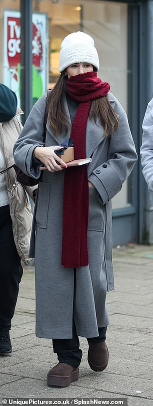 She paired the ensemble with black trousers and added a chic maroon scarf and white beanie for the outing