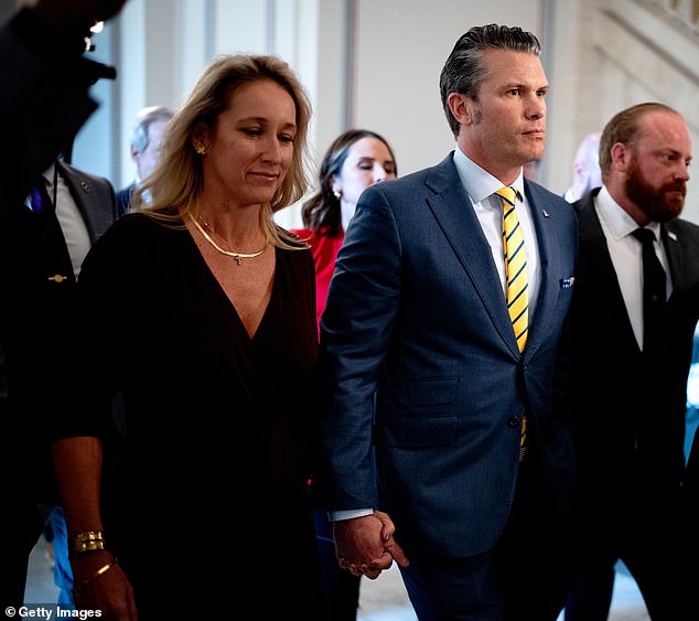 Pete Hegseth and his wife Jennifer Rauchet walk hand-in-hand in the Russell Senate Office Building on Capitol Hill for meetings with senators on Tuesday, December 3