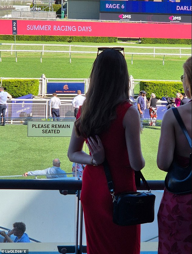 Another racegoer was spotted standing next to a sign that read 'Please remain seated'