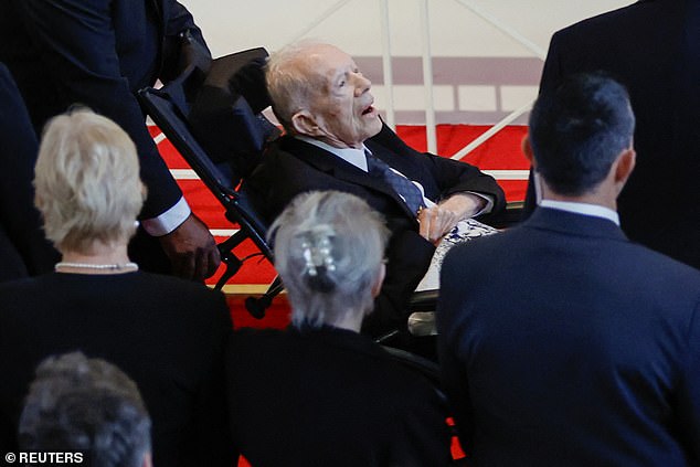 Jimmy Carter died Sunday at the age of 100, nearly two years after announcing he would spend his final days in a hospice. (Image: Jimmy attends his late wife's funeral)