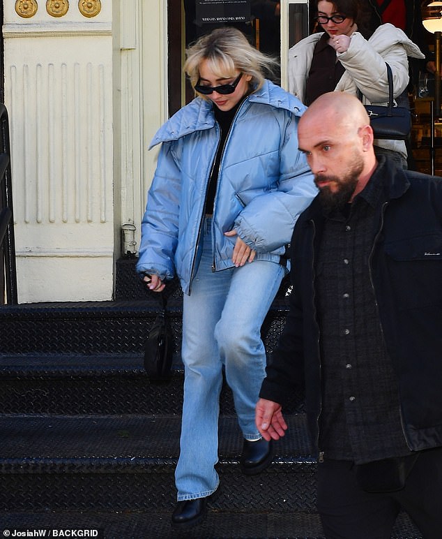 Flanked by security guards, Sabrina – who is now single – strolled down the sidewalk in a loose blue puffer jacket and bootcut jeans