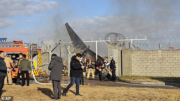 Firefighters and rescue team members work at the Muan International Airport in Muan, South Korea, Sunday, December 29, 2024. (Maeng Dae-hwan/Newsis via AP)