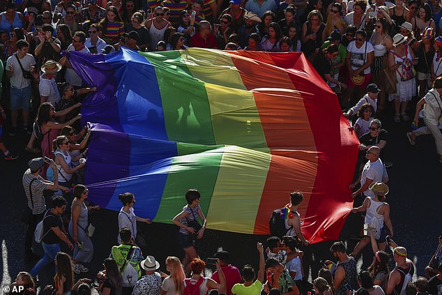 Participants in the annual LGBTQ pride parade carry the rainbow flag in Madrid, Spain