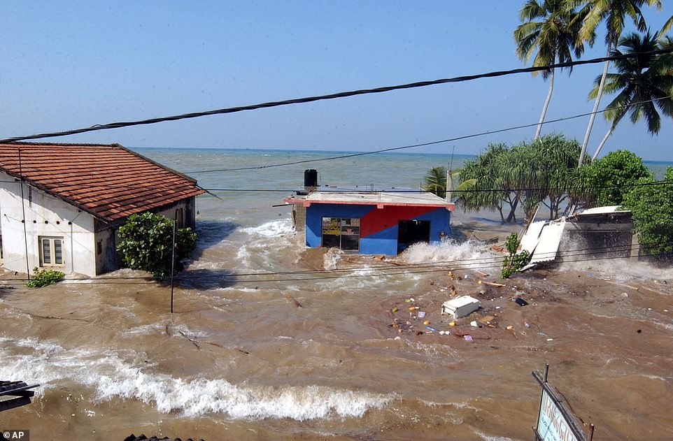 Tidal waves from the Boxing Day tsunami wash through homes in Maddampegama, about 60 kilometers south of Colombo, Sri Lanka