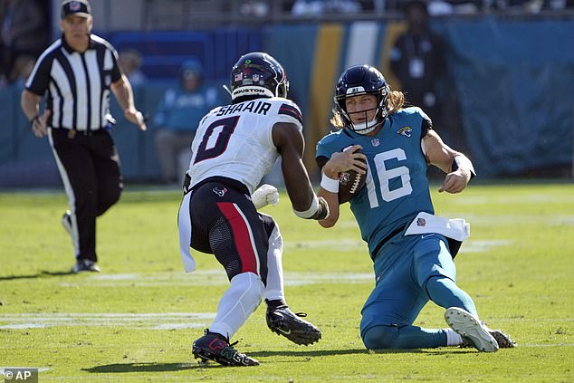 Jacksonville Jaguars quarterback Trevor Lawrence (16) begins to slide downfield as Houston Texans linebacker Azeez Al-Shaair (0) charges forward