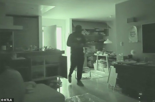 One of the intruders, who was wearing a gas mask, was eerily captured on home security footage opening the front door of the unit before letting himself in.