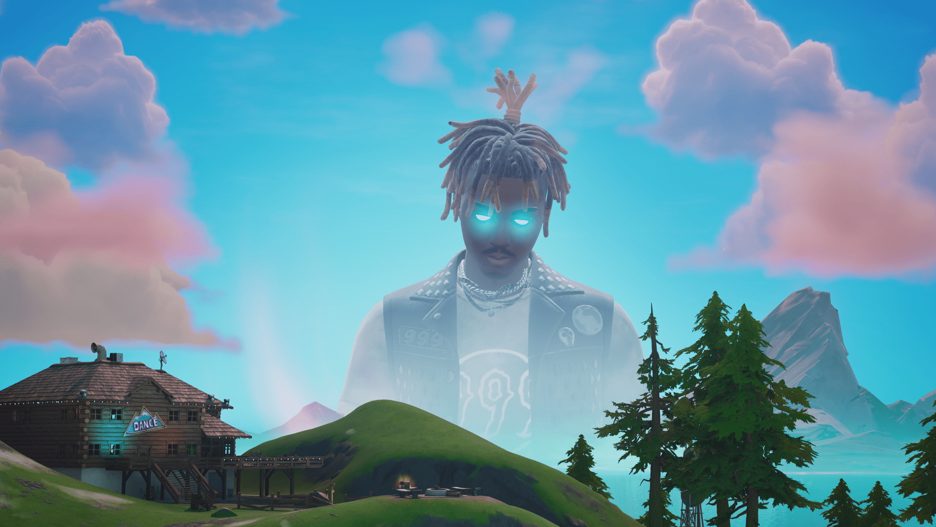 An image of Juice WRLD in Fortnite, with the musician appearing as a ghostly huge statue in the sky, overlooking a log cabin next to a hill and some evergreen trees