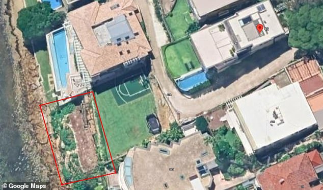 A multi-millionaire has been ordered to halt unapproved construction work on a huge waterfront deck outside his huge mansion (pictured, highlighted)