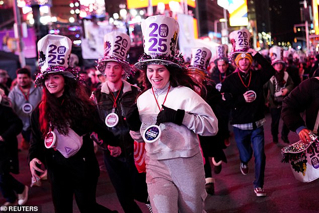 New Yorkers ring in the New Year along with a million people who braved the rain to go to Times Square and watch the iconic ball drop