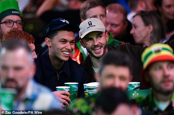 Tottenham Hotspur players Brennan Johnson (left) and James Maddison are seen during the third round match between Jonny Clayton and Gerwyn Price on day twelve of the Paddy Power World Darts Championship at Alexandra Palace, London. Date of photo: Sunday, December 29, 2024. PA Photo. See PA story DARTS World. Photo credit should read: Zac Goodwin/PA Wire. RESTRICTIONS: Use subject to restrictions. Editorial use only, no commercial use without prior permission from the rights holder.