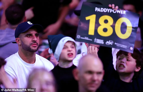 Kyle Walker of Masnchester City (left) during day thirteen of the Paddy Power World Darts Championship at Alexandra Palace, London. Date of photo: Monday, December 30, 2024. PA Photo. See PA story DARTS World. Photo credit should read: John Walton/PA Wire. RESTRICTIONS: Use subject to restrictions. Editorial use only, no commercial use without prior permission from the rights holder.