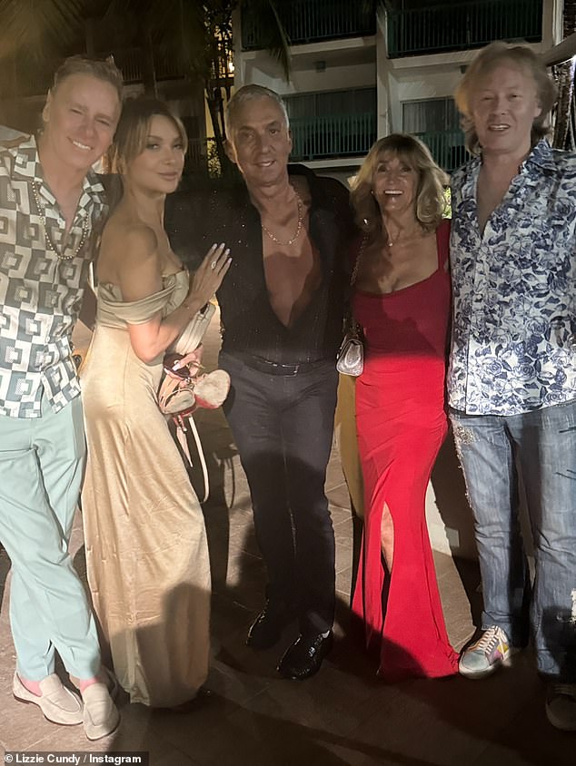 The TV personality was also joined by her boyfriend Bruno Tonioli, 69, (centre), who cut a stylish figure in a black shirt, which he unbuttoned to show off his toned physique.