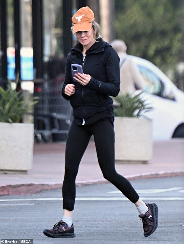 The Oscar winner stepped out in a black jacket and matching leggings with black and blue sneakers. She placed an orange cap with the Texas Longhorns logo on it over her blonde locks