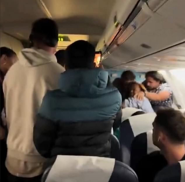 Passengers could be seen trying to push the woman back into her seat after she unleashed a dramatic tirade