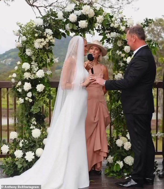 The couple shared their vows in front of friends and family as they stood with a white rose arch as a backdrop