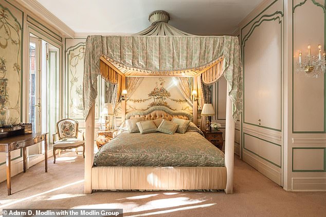 The master bedroom has a private terrace accessed through three charming French doors. The opulent mansion has five bedrooms, one of which has an ornate four-poster bed