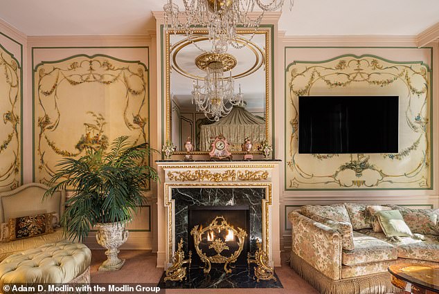 A beautiful gilded marble mantelpiece adds a touch of glamor to this stately lounge