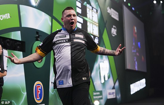 Chris Dobey of England reacts after winning his quarter-final against Gerwin Price of Wales at the World Darts Championship in London, Wednesday, January 1, 2025. (AP Photo/Alberto Pezzali)