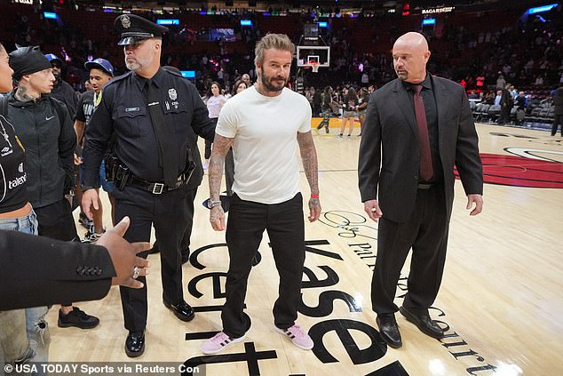 David cut a cool figure and kept his look simple in a plain white T-shirt which he teamed with black jeans and light pink Adidas sneakers.