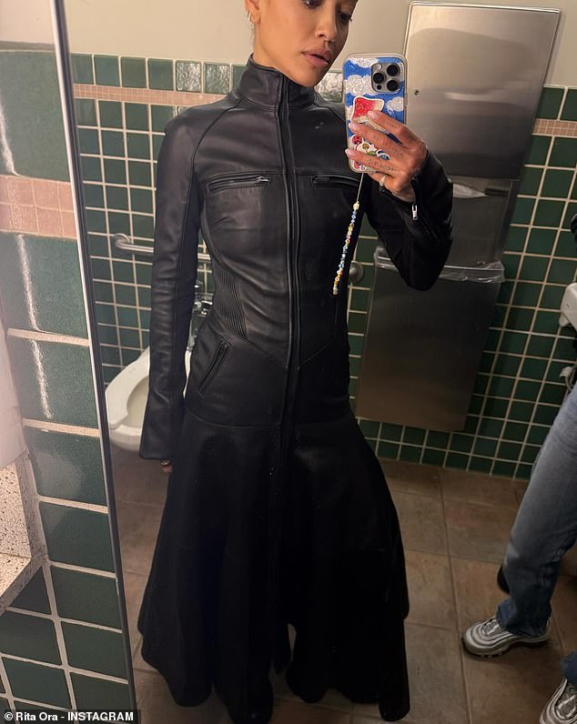 In another stylish look, Rita wore a black leather dress as she took a selfie in a public toilet