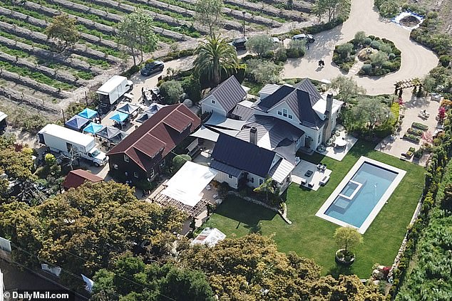 DailyMail.com can reveal that Meghan is not using her own Montecito mansion, but is instead using philanthropists Tom and Sherrie Cipolla's kitchen (production trucks and tents can be seen in the property)