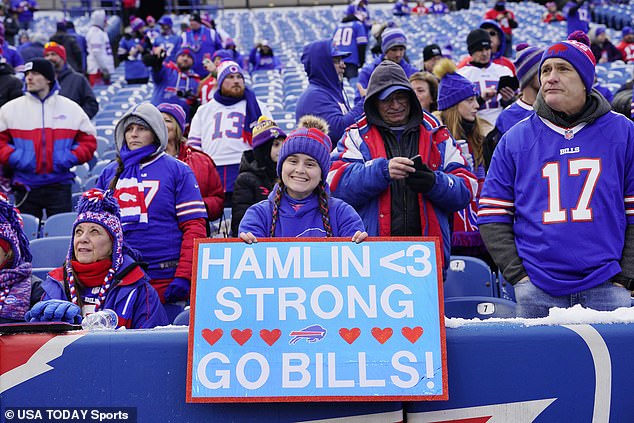 Buffalo Bills fans cheer and hold a sign in support of safety Damar Hamlin (not pictured) before an NFL wild card game against the Miami Dolphins in January 2023