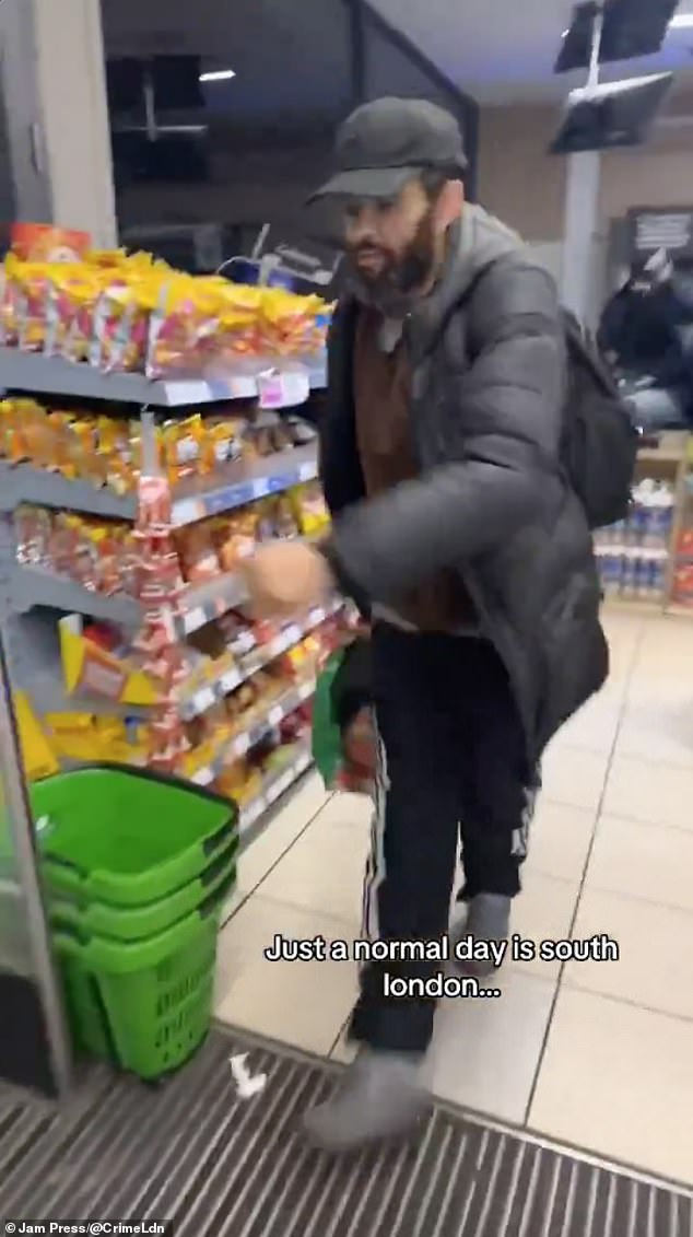 In the video shared online, one of the thieves, pictured, is seen running the store with a bag