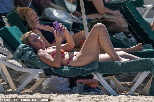 Claire relaxed in the sun as she scrolled through her phone