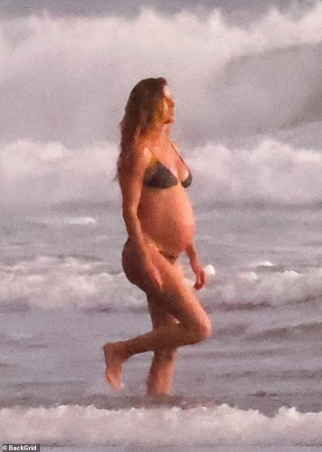 The very pregnant Gisele Bundchen (is she growing a child or a Buick?) looked very caliente as she frolicked in the Costa Rican waves with her handsome lover Joaquim Valente last week.