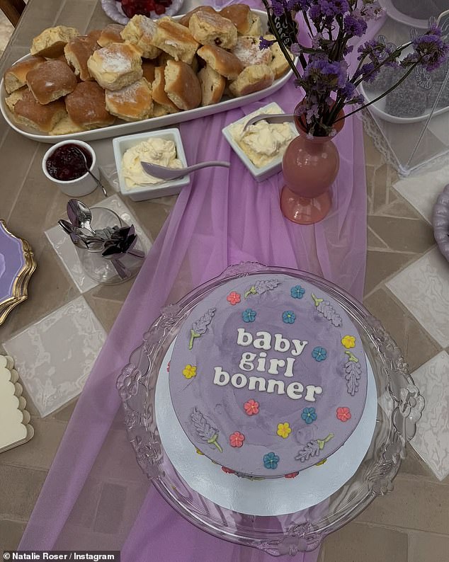 Her pink outfit matched the baby girl theme of the party, with an array of pink and purple decorations and a festive cake.