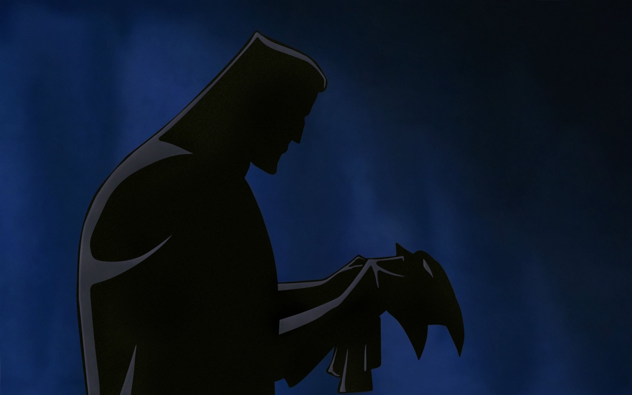 a man looks at a mask in Batman: Mask of the Phantom