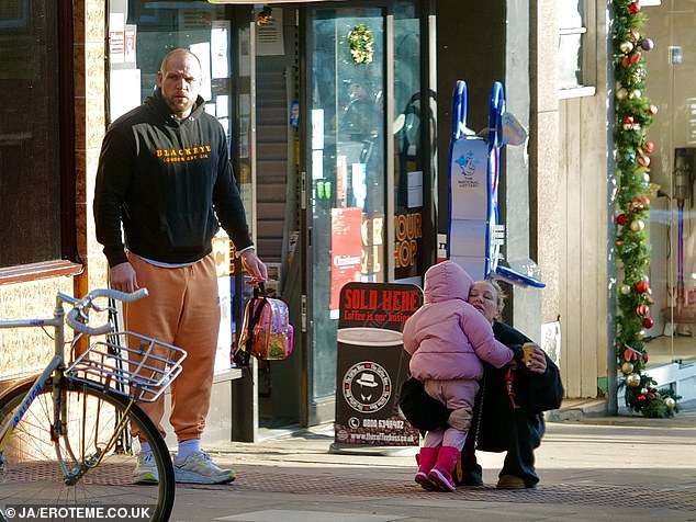 James cut a casual figure in a black hoodie and orange sweatpants while carrying Bodhi, who was dressed in all pink