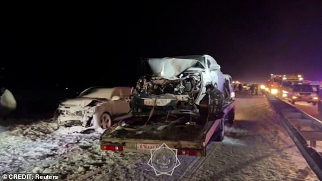 Image shows a wrecked car being towed away by Kazakh authorities