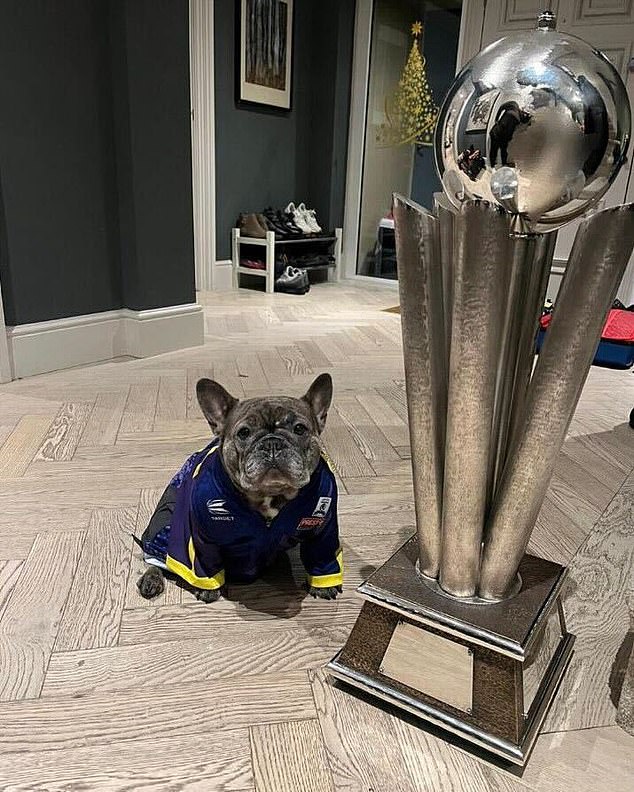 His dog, Nala, also posed with the trophy after Littler became the youngest-ever champion