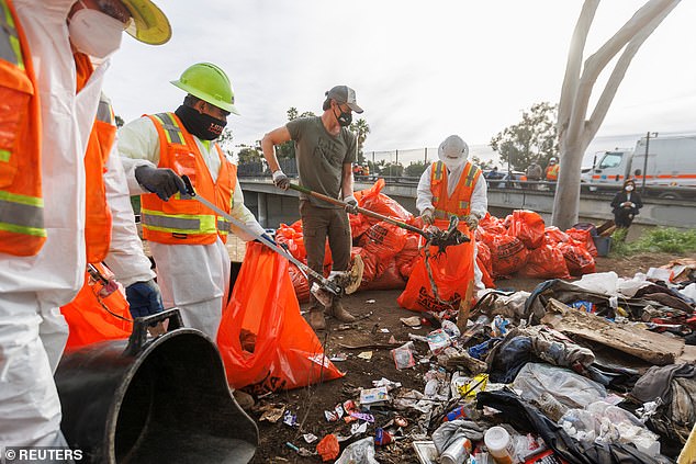 California Governor Gavin Newsom helps clean up a San Diego homeless encampment as Democratic officials take a tougher stance on the problem