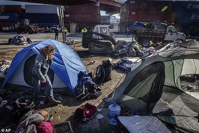 A city work crew arrives at a homeless camp in Portland, Maine, to clear the tents and people