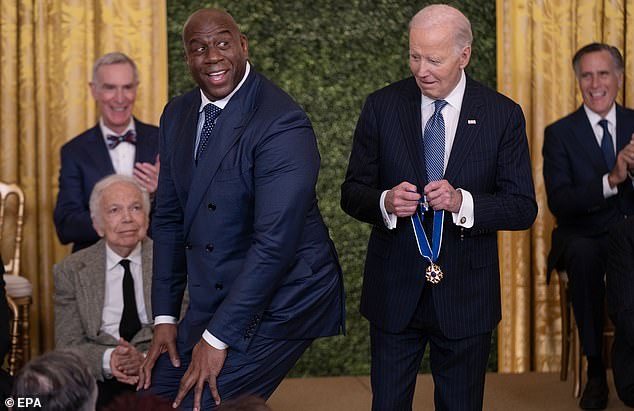 Johnson was forced to crouch so President Biden could wrap the medal around his neck