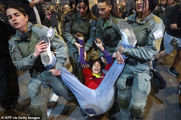 One protester is forcibly removed from outside the IDF headquarters in Tel Aviv