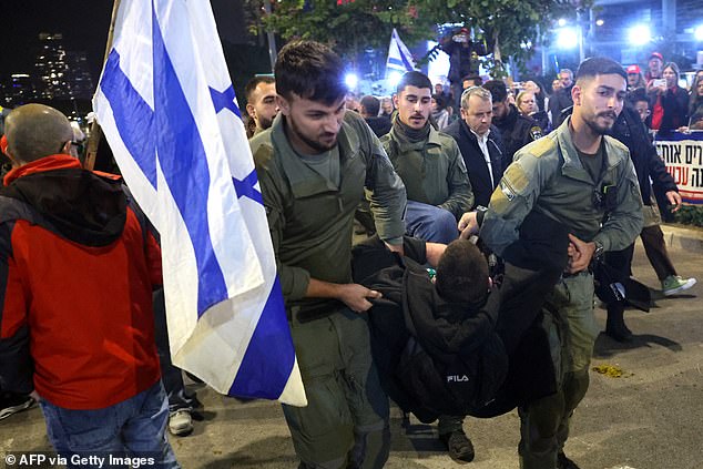 Another demonstrator, this time a man, is carried away from the protest by soldiers