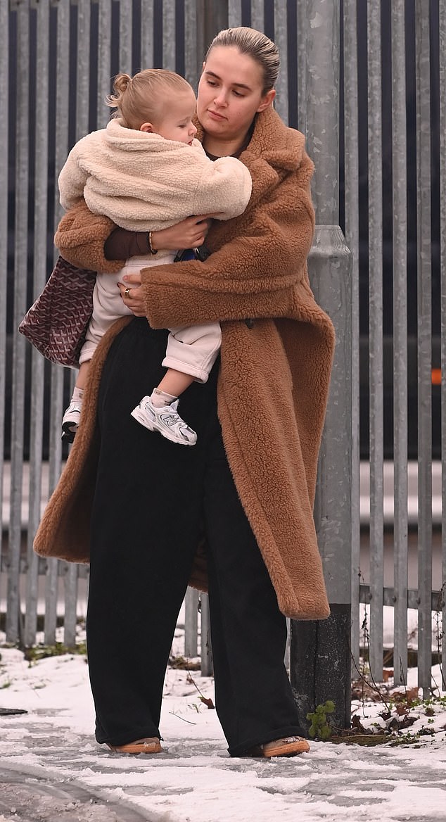 She looked cozy while out and about in a beige teddy coat which she wore with a black tracksuit and trainers amid the snowy conditions in Manchester