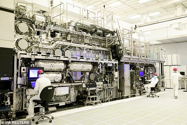 Pictured: Workers are seen in front of a 'High NA EUV' lithography system at an Intel factory in Hillsboro, Oregon, USA.