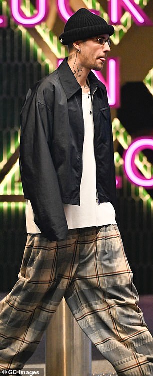 Justin wore baggy plaid pants, an oversized white T-shirt and a navy blue rain jacket