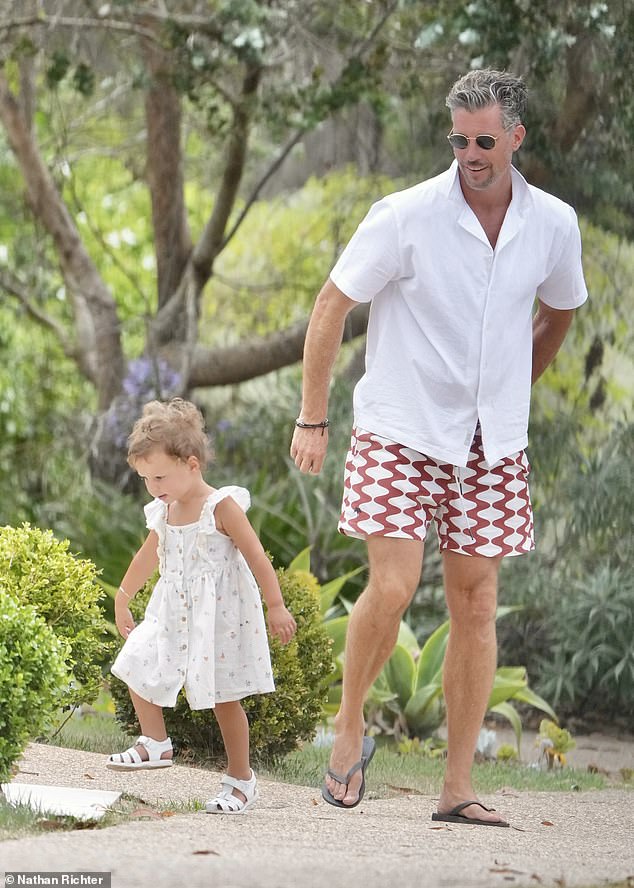 Sam dressed casually in patterned shorts, a white button-up shirt and sunglasses for the outing with his wife and daughters