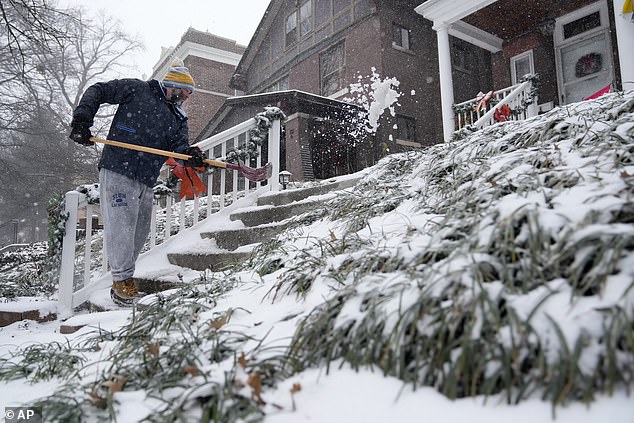 Paul Cullman clears snow from the steps of his home in St. Louis, Missouri, on Sunday