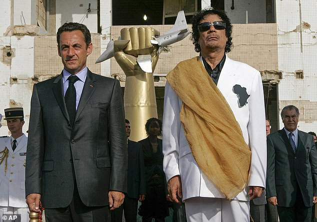 Sarkozy and Gaddafi stand for the Libyan national anthem at the Bab Azizia Palace in Tripoli in 2007