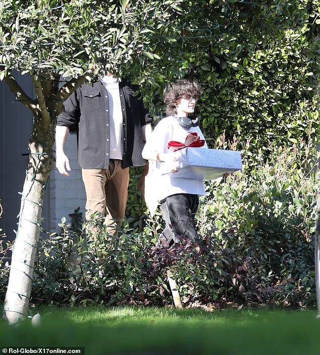 JLo's child Emme, 16, was seen emerging from the property with a large gift in her hands as Ben, 52, walked behind him