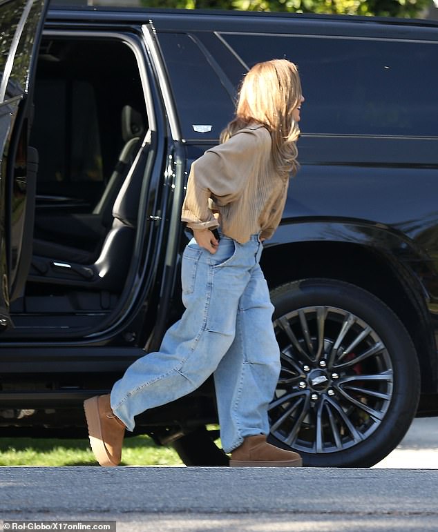 Jennifer wore a copper-colored top, baggy jeans and platform boots