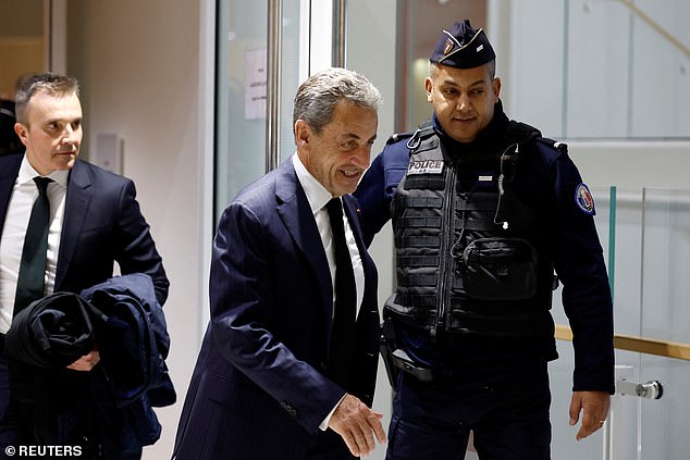 Former French President Nicolas Sarkozy leaves during a break in a hearing on the first day of his trial