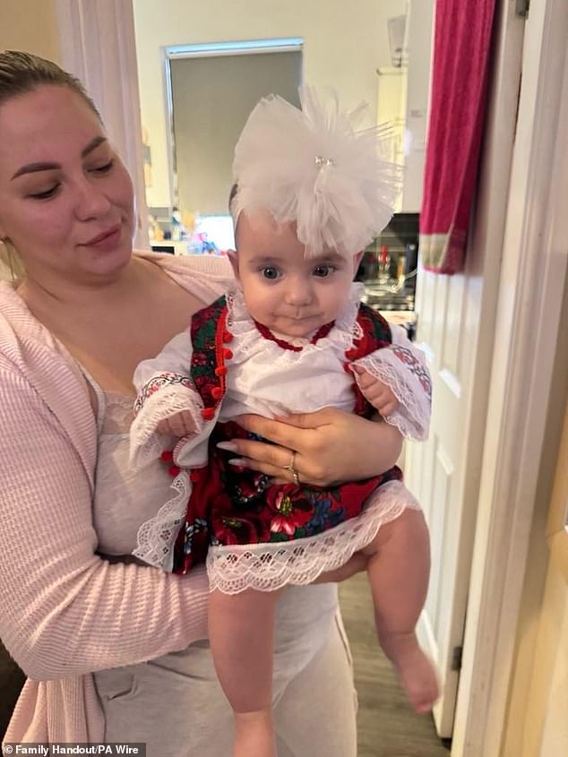 Six-month-old Sophia Kelemen is held by her mother. The baby was taken to hospital with a broken pelvis and a brain haemorrhage and was eventually diagnosed with brain damage from the impact.